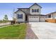 Charming two-story home with three car garage and well-manicured lawn at 9051 Telluride Ct, Commerce City, CO 80022