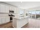 Open kitchen with stainless steel appliances, a quartz island, and sliding doors at 9051 Telluride Ct, Commerce City, CO 80022