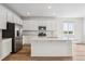 Bright, modern kitchen with white cabinets, stainless steel appliances, and a large center island at 9051 Telluride Ct, Commerce City, CO 80022