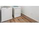 Bright laundry room with wood-look floors and modern washer and dryer at 9051 Telluride Ct, Commerce City, CO 80022