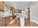 Modern kitchen with stainless steel appliances, center island with bar stools, wood cabinets, and hardwood floors at 12873 E 108Th Ave, Commerce City, CO 80022
