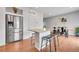 Modern kitchen with a stainless steel refrigerator, center island with bar stools, hardwood floors, and a dining area at 12873 E 108Th Ave, Commerce City, CO 80022