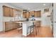 Well-lit kitchen featuring custom cabinets, stainless appliances, granite countertops, and an island with bar seating at 12873 E 108Th Ave, Commerce City, CO 80022
