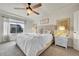 Bright main bedroom featuring large windows, a ceiling fan, and a cozy king-sized bed at 12873 E 108Th Ave, Commerce City, CO 80022