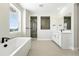 Bright bathroom features a soaking tub, double vanity, and a sleek glass-enclosed shower at 1672 Fox Trotter Pt, Castle Rock, CO 80104