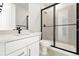 Modern bathroom features a black framed shower, white vanity with black fixtures, and tile flooring at 1672 Fox Trotter Pt, Castle Rock, CO 80104