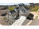 Aerial view of a stunning home with gray siding, stone accents, and a large driveway at 1672 Fox Trotter Pt, Castle Rock, CO 80104