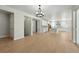 Bright, open-concept living room and kitchen with modern light fixtures and wood-look floors at 1672 Fox Trotter Pt, Castle Rock, CO 80104