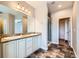 Bright primary bathroom featuring double sinks, granite countertop, large mirror and a walk-in shower at 606 E Dry Creek Pl, Littleton, CO 80122