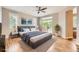 Well-lit main bedroom with a king bed, hardwood floors, large windows, and access to a balcony at 606 E Dry Creek Pl, Littleton, CO 80122