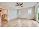 Empty bedroom with hardwood floors, large windows with shutters, and a sliding glass door to a balcony at 606 E Dry Creek Pl, Littleton, CO 80122
