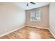 Bright bedroom features wood floors, a modern ceiling fan, and a window with white blinds at 606 E Dry Creek Pl, Littleton, CO 80122