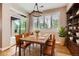 Dining room with a modern table, six leather chairs, sliding glass door to backyard, and plantation shutters at 606 E Dry Creek Pl, Littleton, CO 80122