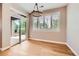 Dining room with a sliding glass door to backyard, plantation shutters, hardwood floors, and modern light fixture at 606 E Dry Creek Pl, Littleton, CO 80122