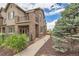 Charming two-story townhouse with brick facade, balcony, and beautifully landscaped walkway at 606 E Dry Creek Pl, Littleton, CO 80122