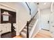 Hallway with access to half bathroom, staircase with wooden railing, and entry to rooms at 606 E Dry Creek Pl, Littleton, CO 80122