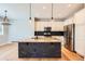 Bright kitchen featuring granite island with dark stone accents, stainless steel appliances and wooden floors at 606 E Dry Creek Pl, Littleton, CO 80122