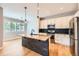 Modern kitchen features a granite island with stone accents, stainless steel appliances, and bright white cabinetry at 606 E Dry Creek Pl, Littleton, CO 80122