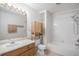 Bright bathroom featuring a shower-tub combo, single sink vanity, and modern wooden storage at 1965 E 127Th Cir, Thornton, CO 80241