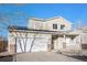 Two-story home with a two-car garage, a front porch, and solar panels under a clear, bright blue sky at 1965 E 127Th Cir, Thornton, CO 80241