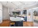 Well-lit kitchen features navy cabinets, stainless steel appliances, a modern lighting fixture, and hardwood floors at 1965 E 127Th Cir, Thornton, CO 80241