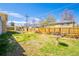 The backyard features a wood fence, wood pile, and open space at 1085 Kingston St, Aurora, CO 80010