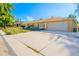 A sunny angle view of this single-story house, boasting a spacious driveway leading to an attached garage at 1085 Kingston St, Aurora, CO 80010