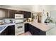 Well-lit kitchen with dark cabinets, a stove, and a microwave at 1140 Magic Lamp Way # 4, Monument, CO 80132