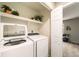 Well-lit laundry room with modern, white, front-loading washer and dryer and open shelving for storage at 1140 Magic Lamp Way # 4, Monument, CO 80132