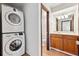 Bathroom features stacked washer and dryer, vanity with wood cabinets at 8460 Decatur St # 138, Westminster, CO 80031