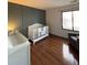 Cozy Bedroom with a crib, hardwood floors, and a large window overlooking the outside at 8787 W Cornell Ave # 6, Lakewood, CO 80227