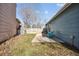 Home's backyard showing concrete patio with blue chair, small playhouse and grassy space, surrounded by wooden fence at 1625 19Th Ave, Longmont, CO 80501