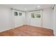 Finished basement with hardwood flooring, neutral walls and two bright windows at 5653 E Southmoor Cir, Englewood, CO 80111