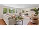 Bright living room features large windows, a comfortable couch, stylish decor, and hardwood flooring throughout at 5653 E Southmoor Cir, Englewood, CO 80111
