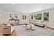 Spacious living room is brightened with large windows, a comfortable sofa set, and hardwood flooring throughout at 5653 E Southmoor Cir, Englewood, CO 80111