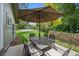 Outdoor dining area with a patio umbrella in a fenced-in backyard at 5653 E Southmoor Cir, Englewood, CO 80111