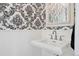 Powder room features pedestal sink, and designer wallpaper at 5653 E Southmoor Cir, Englewood, CO 80111