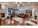 Open-concept living room featuring a fireplace, hardwood floors, and a seamless flow into the kitchen at 7851 E 148Th Dr, Thornton, CO 80602