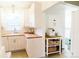 Well-lit kitchen with white cabinets, butcher block counters, and a convenient rolling island at 4212 Lowell Blvd, Denver, CO 80211