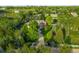 Aerial view of an estate with brick home, circular driveway and professional landscaping in a wooded area at 5700 S Steele St, Greenwood Village, CO 80121