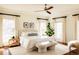 A bright bedroom with large windows, neutral walls, decorative art and a bench at the foot of the bed at 5700 S Steele St, Greenwood Village, CO 80121