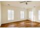 Bright bedroom featuring hardwood floors, white walls, and large windows with plantation shutters at 5700 S Steele St, Greenwood Village, CO 80121