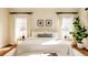 A brightly lit bedroom featuring neutral walls, large windows, two side tables and decorative art at 5700 S Steele St, Greenwood Village, CO 80121