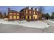 Classic brick home featuring dormer windows, and a manicured lawn partially covered in snow at 5700 S Steele St, Greenwood Village, CO 80121