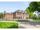 Stately brick home featuring a circle driveway, well-manicured lawn, and classic architectural design at 5700 S Steele St, Greenwood Village, CO 80121