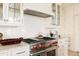 Detailed view of the kitchen with a stainless steel range, white subway tile backsplash, and marble countertops at 5700 S Steele St, Greenwood Village, CO 80121