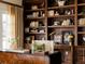 Close up of a well-organized office featuring dark wood bookshelves, a desk, and stylish decor at 5700 S Steele St, Greenwood Village, CO 80121