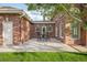 Charming outdoor patio with a dining table, brick accents, and a view of the lush green lawn at 5700 S Steele St, Greenwood Village, CO 80121