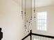 Elegant staircase features a modern light fixture with glass pendants and a bright window providing natural light at 5700 S Steele St, Greenwood Village, CO 80121