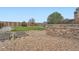 Landscaped backyard featuring a stone patio, garden beds, gravel, and a play structure at 5130 S Wenatchee St, Aurora, CO 80015